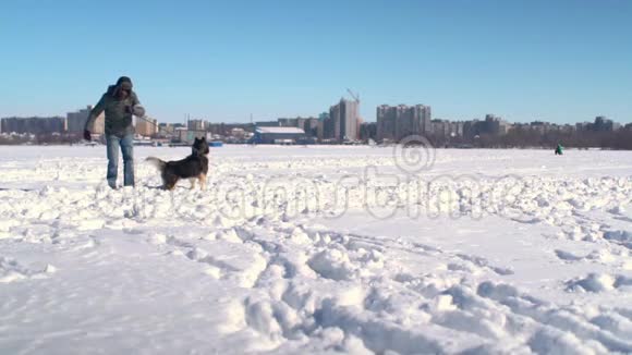 哈士奇狗和奇怪的滑稽男人在大雪中缓慢地朝镜头跑去视频的预览图
