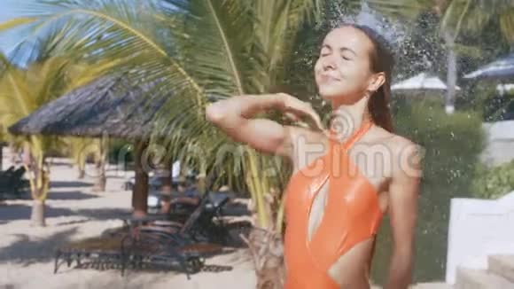 穿着比基尼的女孩在棕榈滩沐浴时闭上眼睛视频的预览图