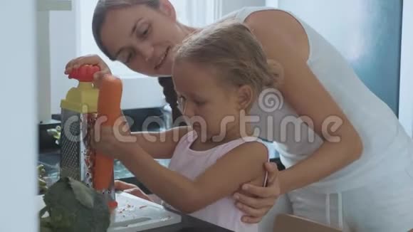 小女孩在磨盘上摩擦胡萝卜在家庭厨房里吃视频的预览图