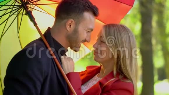 彩虹伞下浪漫情侣的特写视频的预览图