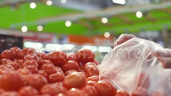 女人超市里挑选新鲜多汁的西红柿视频的预览图