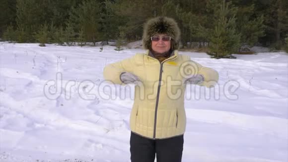 成熟的白种人成年妇女在冬季森林里做运动女人在户外做热身或运动视频的预览图