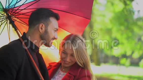 彩虹伞下浪漫情侣的特写视频的预览图