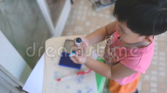 创意男孩使用蓝墨水和邮票在纸上作为艺术作品从高角度视频的预览图
