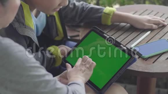 母子俩一起用数字平板绿屏色度键视频的预览图