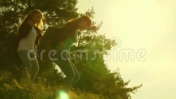 流浪女孩从山上下来徒步旅行者女孩日落时旅行的游客家庭带背包的姐妹视频的预览图