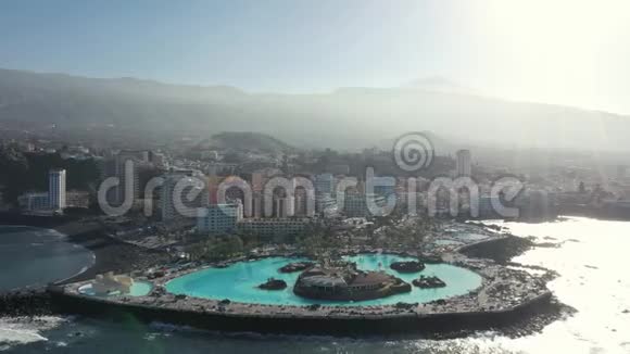 在太阳照射下在半岛上的鸟瞰酒店游泳池视频的预览图