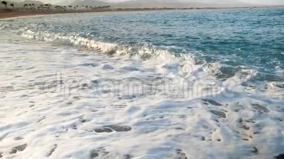 日落时海浪在金色沙滩上翻滚的极端慢动作视频视频的预览图