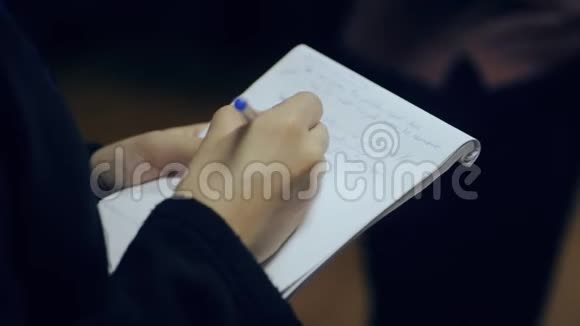 亲密的双手射击漂亮的女性在笔记本上记笔记视频的预览图