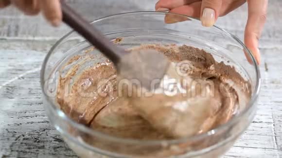 女性手用刮刀搅拌巧克力面糊视频的预览图