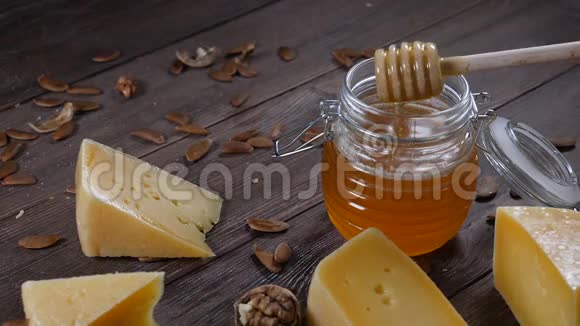 蜂蜜和奶酪提供餐厅餐桌服务木质背景的硬奶酪和坚果视频的预览图