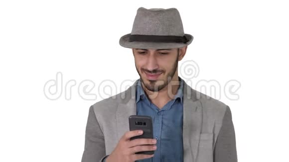 聪明休闲的阿拉伯男人在白色背景下行走时使用智能手机视频的预览图