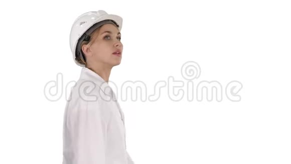 戴着安全帽的年轻女子在白色背景下走来走去视频的预览图