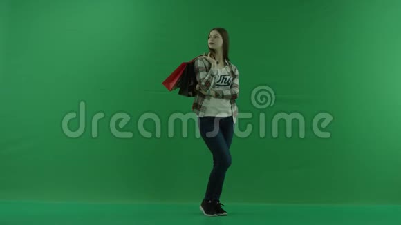 女孩站在一个半转弯处向右看肩膀上有包裹等待绿色的东西视频的预览图
