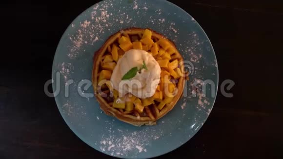用比利时华夫饼冰淇淋和芒果吃甜食顶部视图视频的预览图