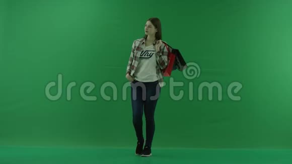 女孩站在半个转弯处看着左边把袋子扔在绿色屏幕上的肩膀上视频的预览图
