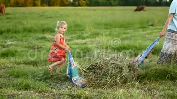 妈妈和女儿把干草从田里拿出来村家庭视频的预览图