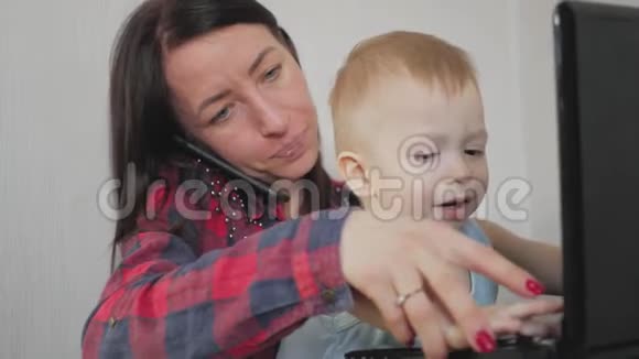 多任务自由职业和母性概念在家工作的母亲小男孩和笔记本电脑家庭母亲视频的预览图