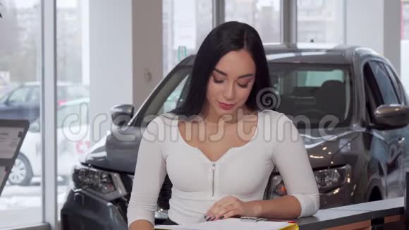 美丽的女人微笑着在买了新车后拿着车钥匙视频的预览图