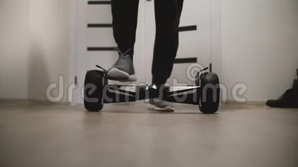 近景男性腿踩在电动Hyroscooter在现代办公空间白色墙壁和移动视频的预览图