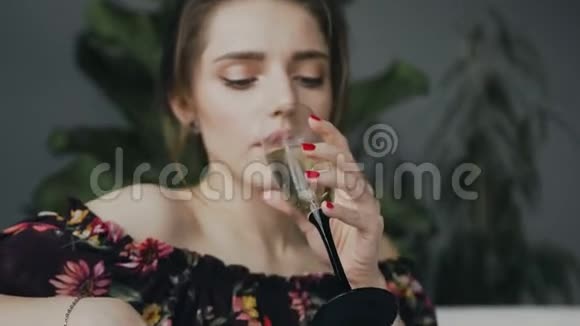 一个在浴室喝香槟的可爱年轻女人的肖像年轻的美女喝香槟放松视频的预览图