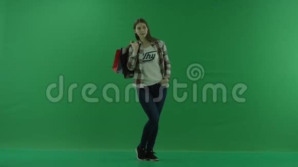 女孩站在半个转弯处看着右边把袋子扔在绿色屏幕上的肩膀上视频的预览图