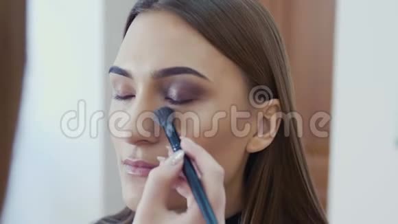化妆师用眼影化妆来塑造的眼睛关闭视野烟熏的眼睛正确的看法视频的预览图