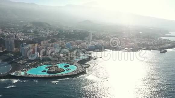 海岸岛上的建筑物和山丘被海水冲刷视频的预览图