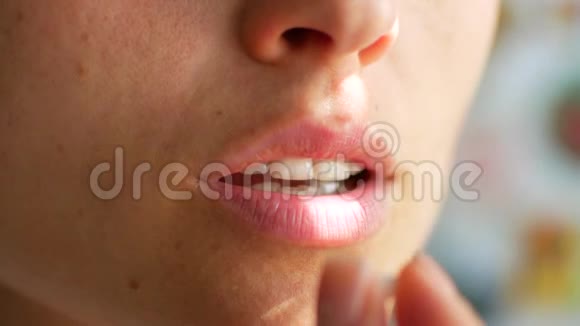 一个女人把一粒药丸放进嘴里用水喝特写镜头视频的预览图