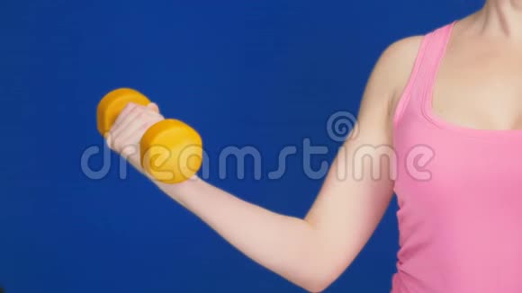 一个穿着一件深领口的粉红色T恤的女人做哑铃凳锻炼肱二头肌复制空间视频的预览图