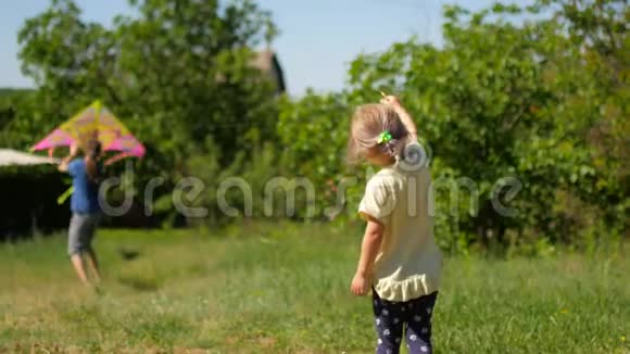 女孩在美丽的花园里玩风筝视频的预览图