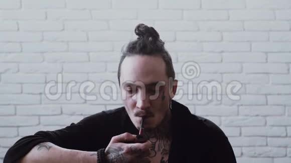 有胡茬的人点着烟男人抽烟有纹身的拉斯塔人视频的预览图