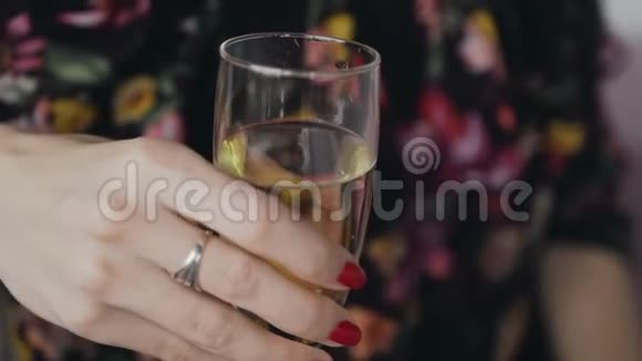 年轻女子手里拿着一杯香槟女孩手里拿着一杯白酒一杯香槟视频的预览图
