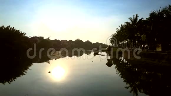 棕榈树的轮廓和阳光反射在懒洋洋的河中视频的预览图
