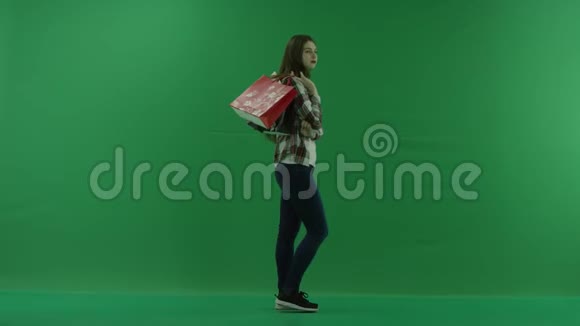 女孩站在她的右边肩上扛着包裹在绿色的屏幕上等待着什么视频的预览图