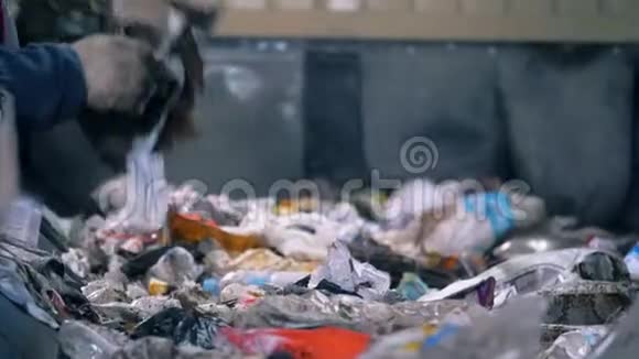 工厂工人在一条线上分类垃圾特写工人在满是垃圾的移动线上分类纸张视频的预览图