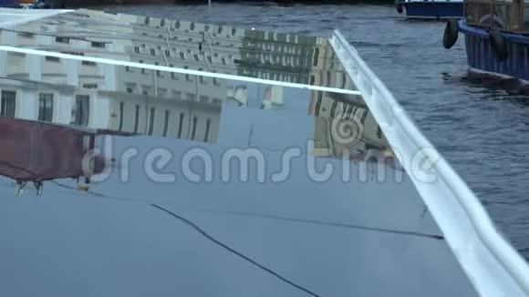 从船的玻璃屋顶反映城市的建筑物和结构视频的预览图
