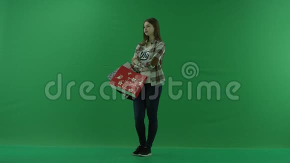 女孩站在半个转弯处向左看把包放在她弯曲的胳膊肘上等待绿色的东西视频的预览图