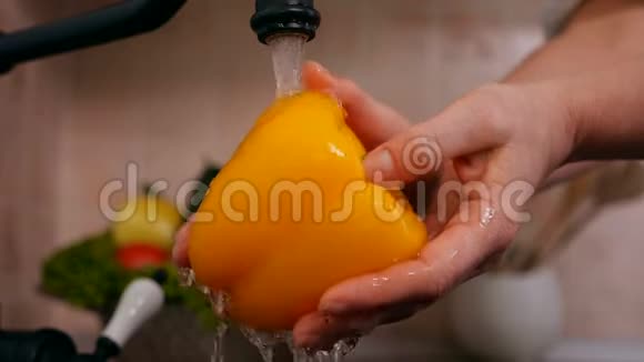 女人在厨房洗手池洗手黄钟椒慢动作视频的预览图