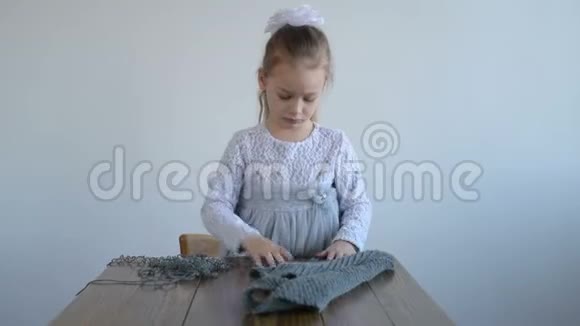 可爱的女孩解开灰色编织视频的预览图