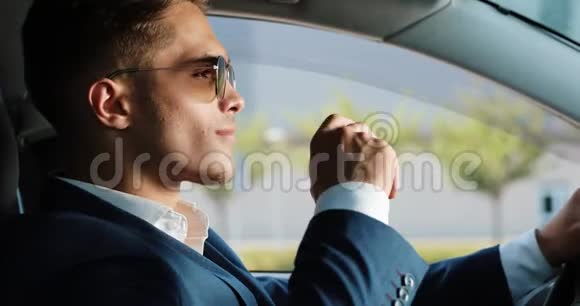 年轻成功的商人摘下太阳镜看着坐在车里的相机商业人视频的预览图