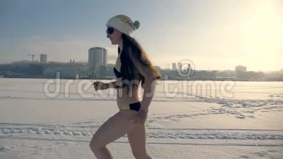 一个女人在结冰的河流上的雪上奔跑视频的预览图