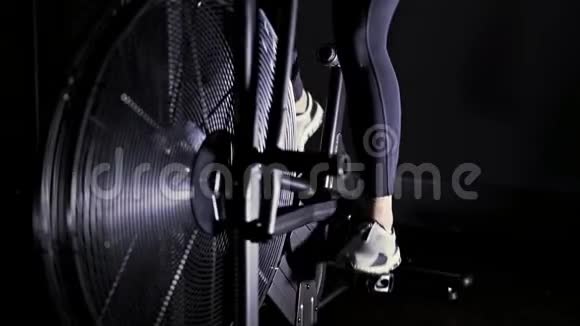 女人的双腿穿着白色运动鞋在健身房里骑着自行车视频的预览图
