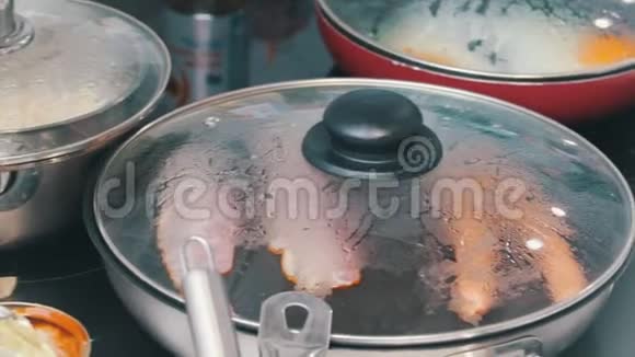 咖啡馆里的厨房在锅里做一顿英式早餐煎鸡蛋培根和香肠视频的预览图