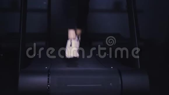 女人的腿穿着白色运动鞋黑色的腿在跑步机上视频的预览图