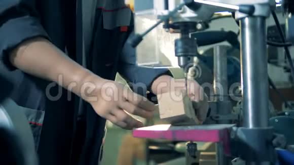 有假肢的工程师在一家工厂工作钻一根木棒4K视频的预览图
