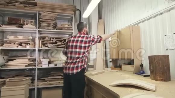 穿着长胡子衬衫的木匠在车间里用工具视频的预览图