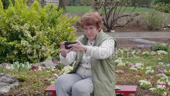 高级女性在户外用手机拍照自拍视频的预览图