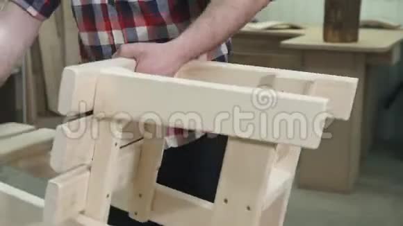 木匠在车间里穿着一件有胡须的衬衫工作做了一把木椅视频的预览图
