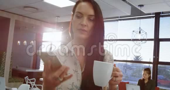 女高管一边喝咖啡一边用手机说话视频的预览图